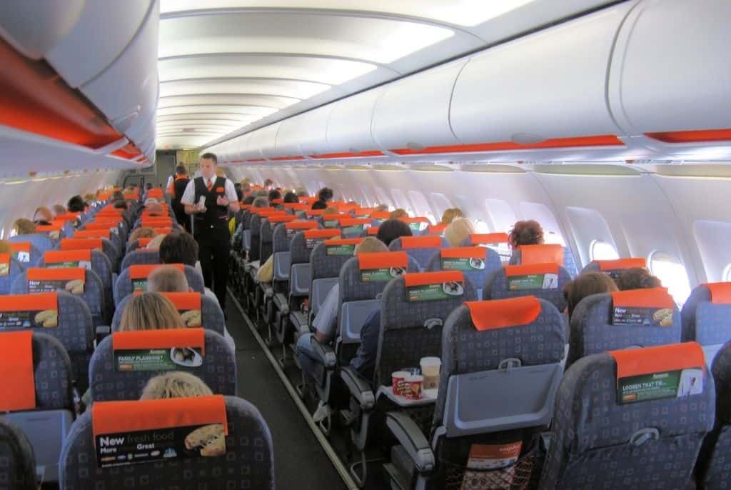 Pra-todos-verem:Interior-de-uma-aeronave-com-passageiros-e-comissários-como-comprar-Passagens-aéreas-baratas